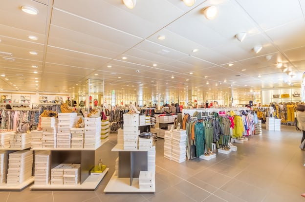 Racks of clothing and shoes sit inside a brightly lit interior.