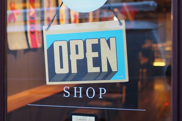 A blue “Open” sign on a store window.